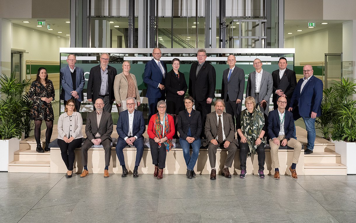 Gruppenbild im Atrium des AOK-Bundesverbandes in Berlin, hintere Reihe elf Personen (drei Frauen), vordere Reihe acht Personen (vier Frauen)