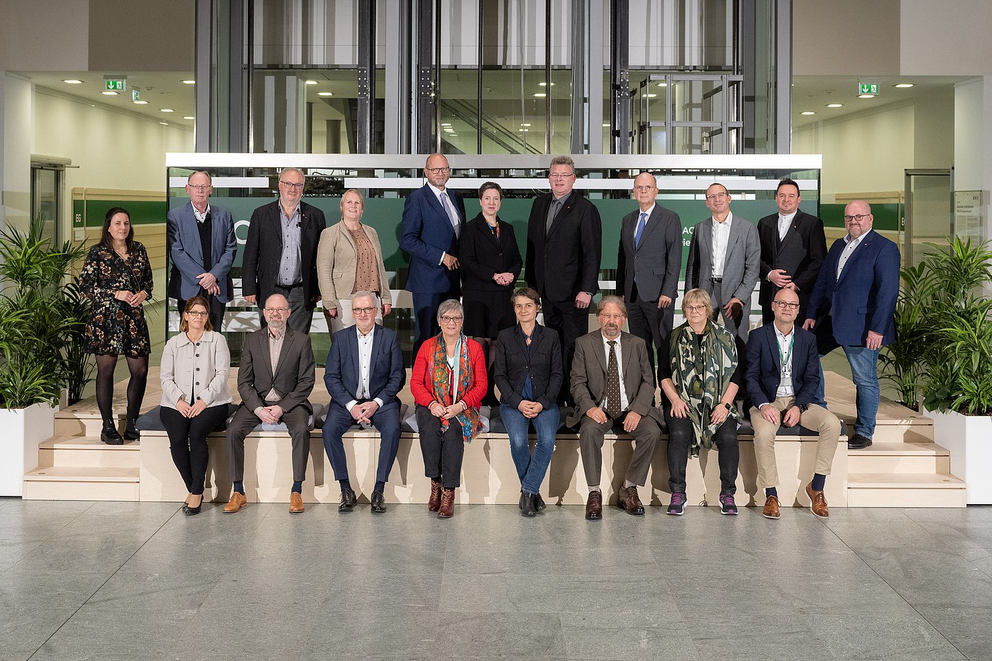 Gruppenbild im Atrium des AOK-Bundesverbandes in Berlin, hintere Reihe elf Personen (drei Frauen), vordere Reihe acht Personen (vier Frauen)