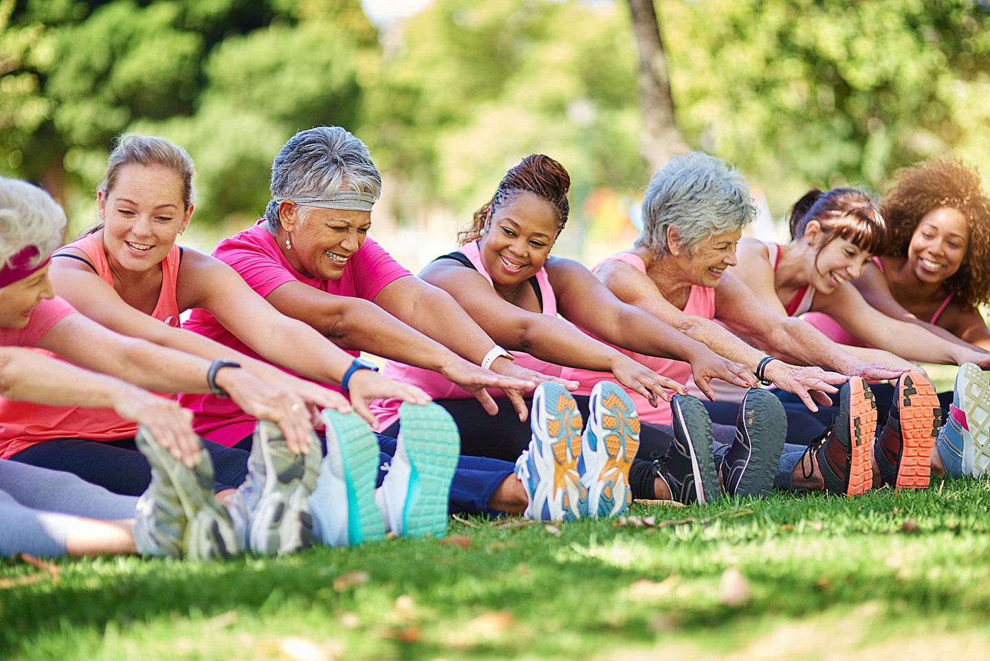 Das Foto zeigt eine Gruppe Frauen, die im Freien gemeinsam Sport treibt.
