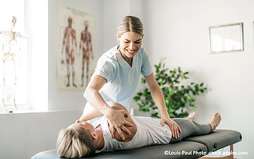 Physiotherapeutin behandelt eine Patientin in einer Praxis