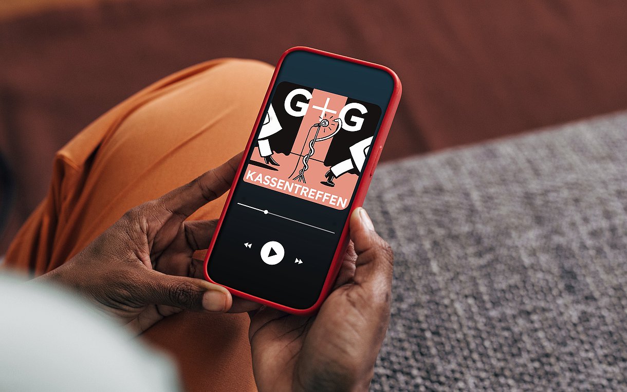 Foto einer Person, die ein Handy in der Hand hält, auf der das Logo des G+G-Podcasts zu sehen ist