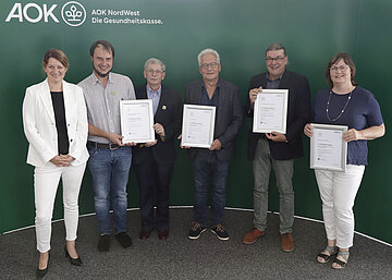 Foto zeigt die Vertreter der &Auml;rztenetze aus Schleswig-Holstein, die von AOK-Landesdirektorin Iris Kr&ouml;ner mit dem QuATRo-Qualit&auml;tssiegel geehrt werden.