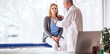 &Auml;rztliche Untersuchung: EIn Arzt h&ouml;rt mit einem Stethoskop den Brustkorb einer Patientin ab.