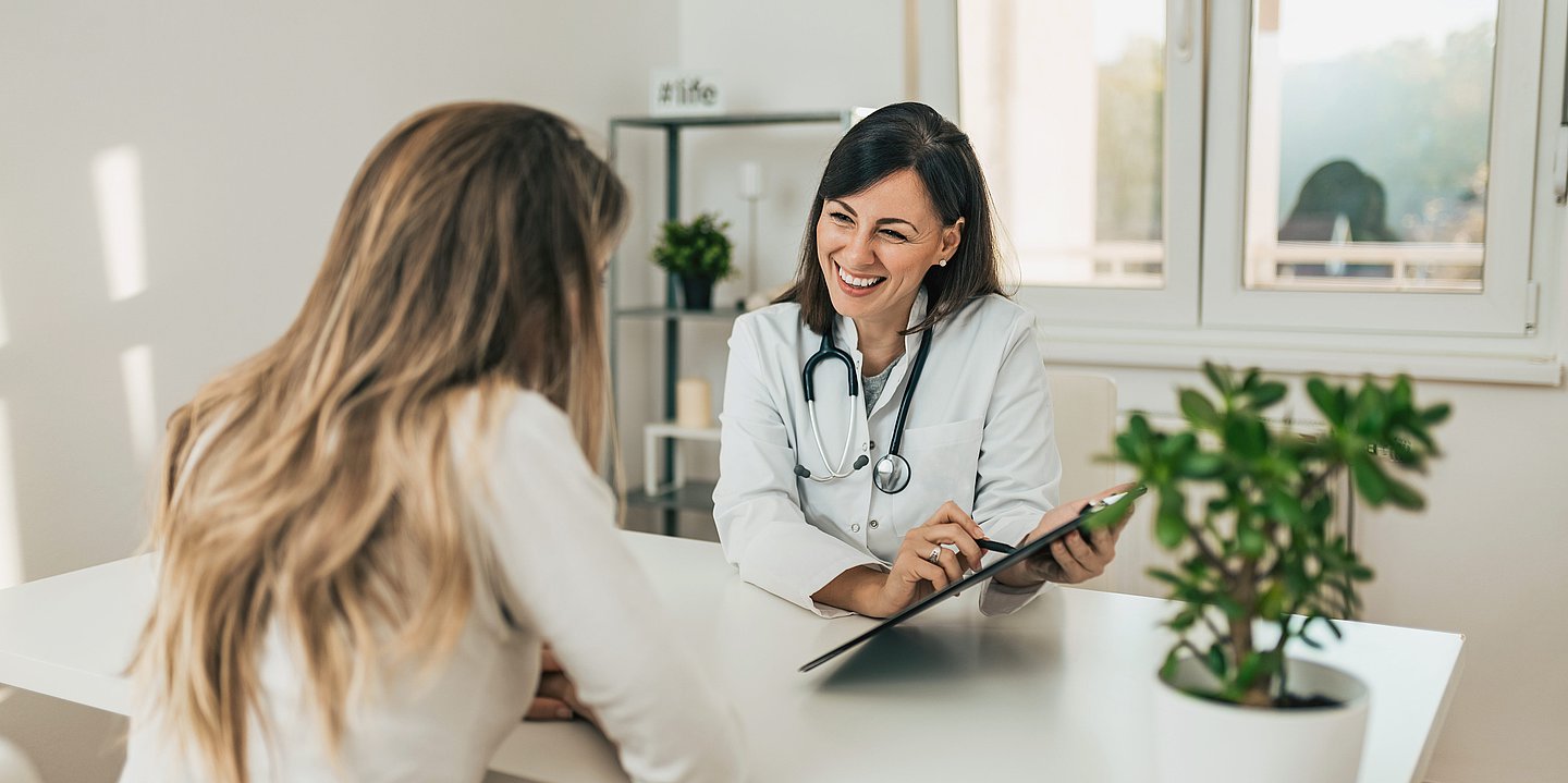 Eine Ärztin und eine Patientin befinden sich in einem freundlichen Gespräch