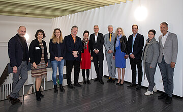 Vertreterinnen und Vertreter des Innovationsfondsprojekts Home BASE l&auml;cheln bei einem gemeinsamen Fototermin in die Kamera