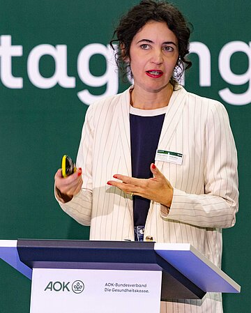 Anna-Lena von hodenberg steht an einem Rednerpult und spricht.