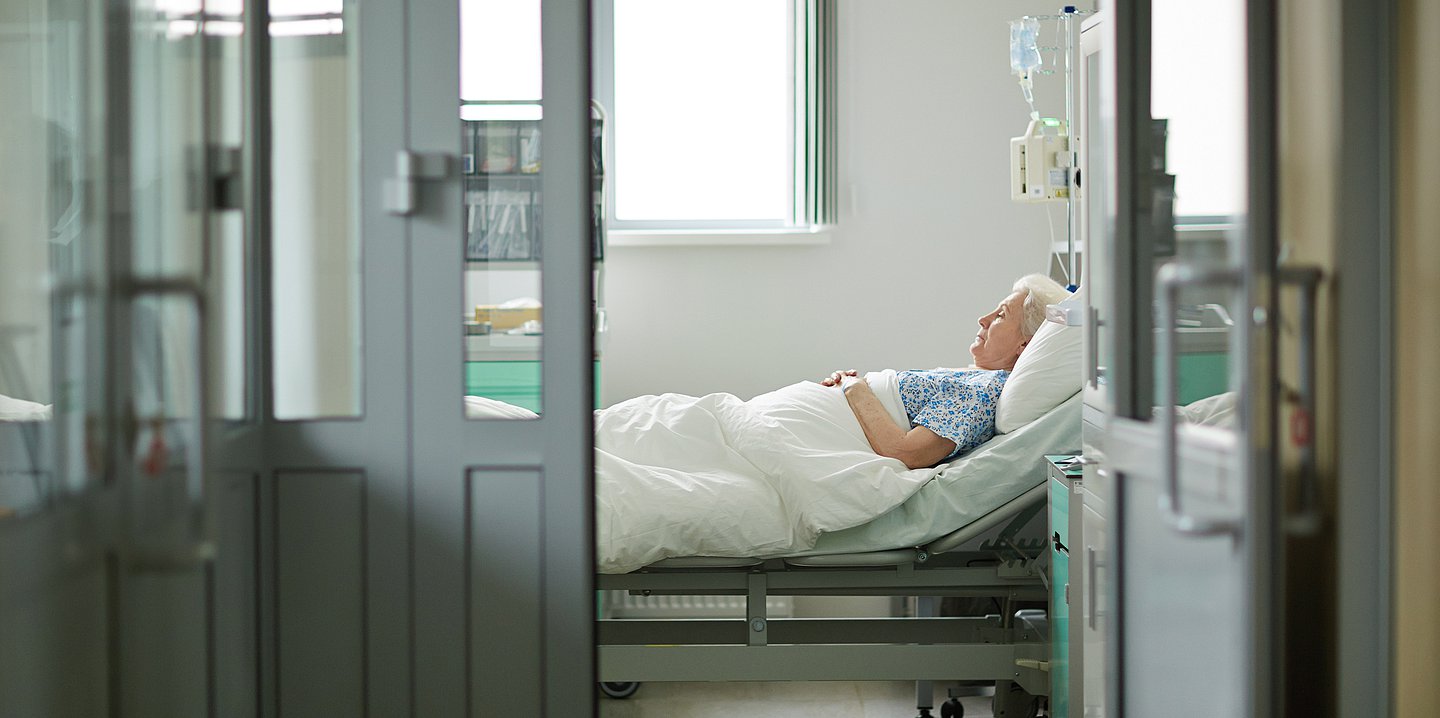 Foto: Eine ältere Dame liegt im Krankenhausbett.