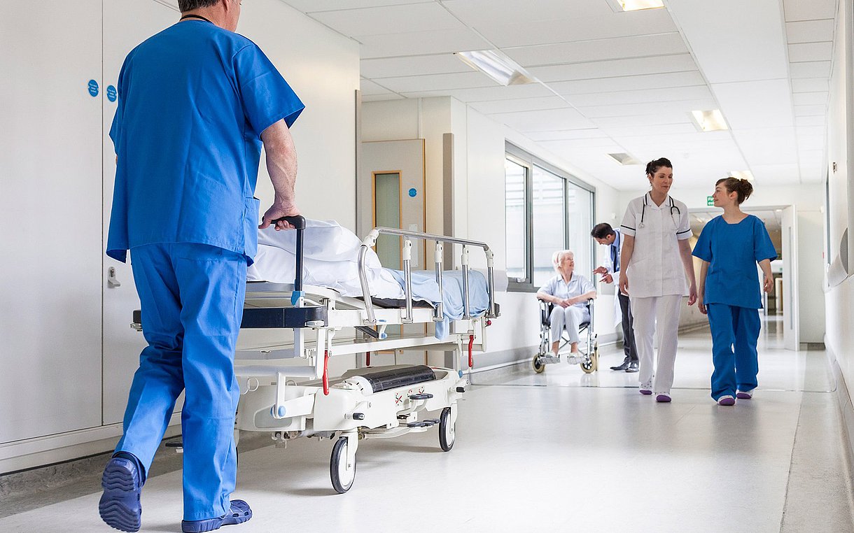 Foto von medizinischem Personal und Patienten in einem Krankenhausflur