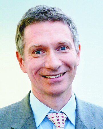 Portr&auml;tfoto zeigt Christian G&uuml;nster, Leiter der Abteilung Versorgungsforschung im WIdO, bis zum Krawattenknoten, hellblaues Hemd, hellgraues, leicht karriertes Sakko