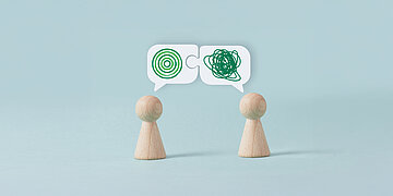 Zwei Spielfiguren stehen sich gegen&uuml;ber und haben Sprechblasen mit unklaren Zeichen &uuml;ber den K&ouml;pfen.