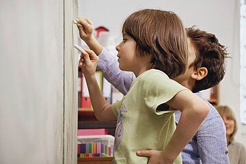 Schmuckbild mit Kindern an der Schultafel