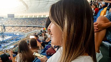 AOK-Umfrage Sport-Events in Schleswig-Holstein Foto zeigt im Vordergrund das Gesicht einer Besucherin, die im Fußball-Stadion ein Event verfolgt.