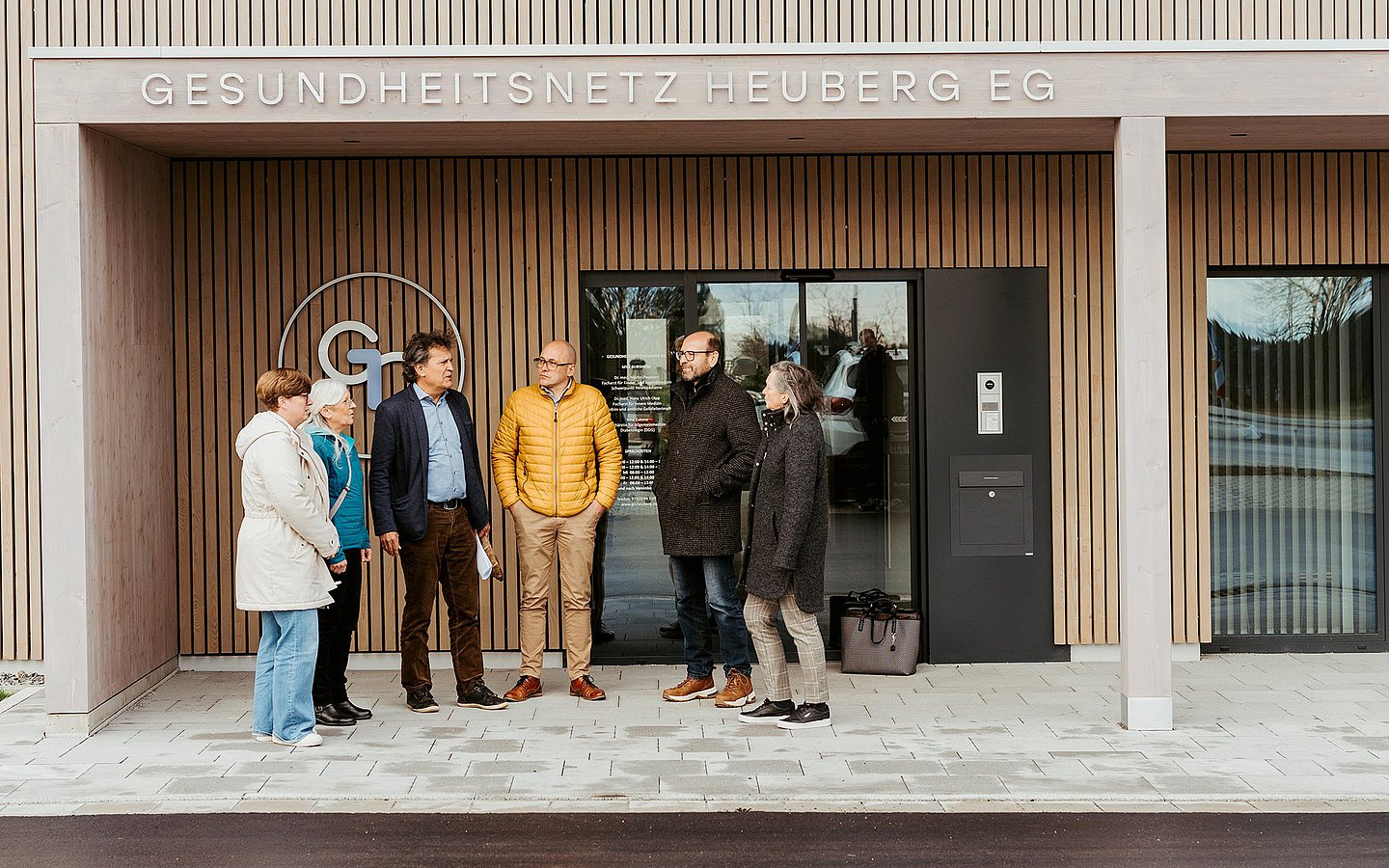 Foto verschiedener Personen vor einem MVZ: Vera Felisoni (Nachbarschaftsverein), Marianne Thoma (Landratsamt), Thomas Leibinger (Bürgermeister), André Saliger (Gesundheitsnetz), Johann Stehle (Pflegedienstleiter) und Veronika Hermle-Wehl (Patientenlotsin)