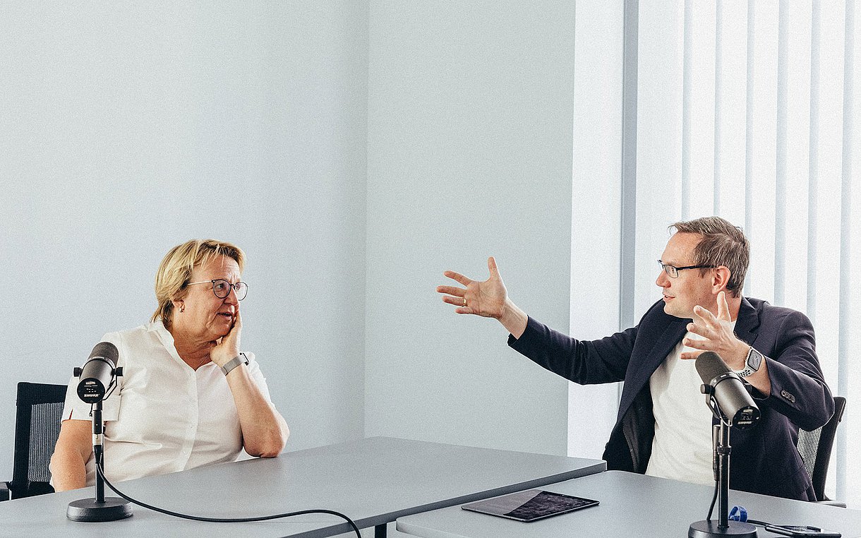 Foto von Sylvia Thun und Kornell Adolph, wie sie an einem Konferenztisch diskutieren