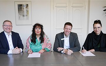 Sven Busch, Claudia Graf, J&uuml;rgen Weber und Bettina Lammers sitzen nebeneinander an einem Tisch.