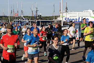 Blick auf die Kieler F&ouml;rde: Im Hintergrund sieht man die 'Stena Line', im Vordergrund zahlreiche L&auml;uferinnen und L&auml;ufer auf der Laufstrecke beim AOK-Business.Run.