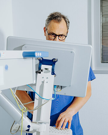 Foto: Christian Karagiannidis arbeitet konzentriert an einem medizinischen Computerarbeitsplatz.