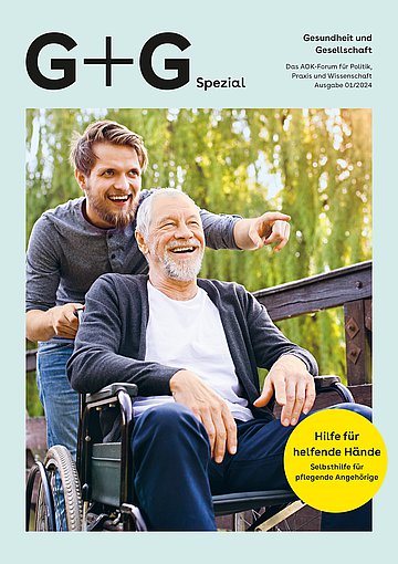 Foto: Ein junger Mann schiebt einen älteren Mann im Rollstuhl und zeigt auf etwas.