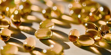 Tabletten im Sonelicht Foto zeigt dutzende Dragees, die der Sonne ausgesetzt sind. Es macht den Eindruck, als seien sie leicht in Bewegung.
