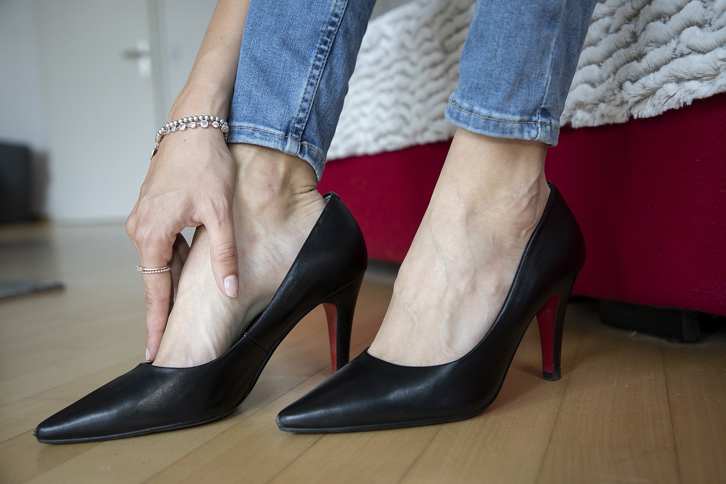 Eine Person in High Heels reibt sich ihren Fuß.
