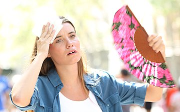 Auf dem Foto ist eine Frau mit einem F&auml;cher in der Hand zu sehen.