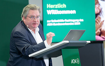 Gerriet Schr&ouml;der steht bei seinem Vortrag auf der AOK-Selbsthilfe-Fachtagung hinter einem Rednerpult.