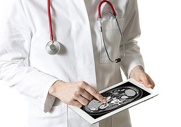 Arzt mit Tablet Ein Arzt betrachtet auf einem Tablet eine Röntgenaufnahme.