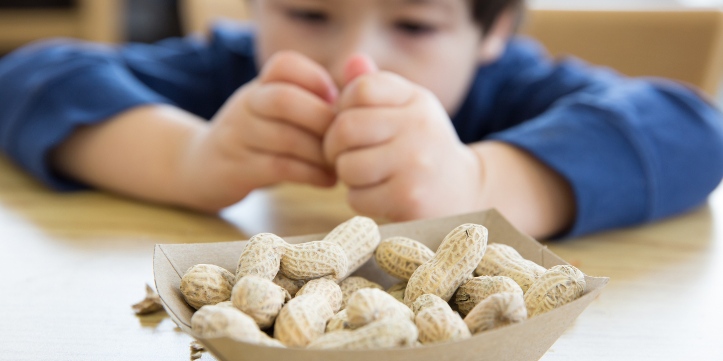 Ein kleiner Junge knackt Erdnüsse.