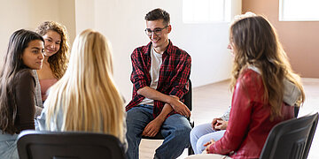 Foto von jungen Menschen im Stuhlkreis in einer Selbsthilfegruppe