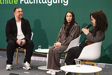 Die Influencerinnen Melisa Akdag (mi.) und Janina Nagel (re.) im Gespr&auml;ch mit Moderator Michael Bernatek auf dem Podium