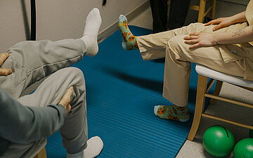 Foto: Sitzende Patienten im Gymnastikraum.