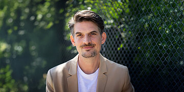 Porttr&auml;tfoto: Dr. Christoph-Gerard Stein, Mediziner bei der AOK Hessen, aufgenommen vor einer Reihe B&auml;umen.