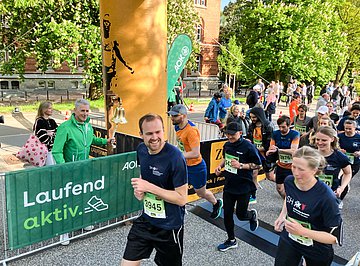 Der ‚AOK-Business.Run Kiel‘ in Schleswig-Holstein AOK-Serviceregionsleiter Stefan Kölpin startet vor dem Landtag den AOK-Business.Run mit dem Läuten einer Glocke, die Läuferinnen und Läufer setzen sich in Bewegung.