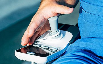 Foto von der Hand des Charité-Arztes Dr. Leopold Rupp, wie er den Joystick seines Rollstuhls bedient