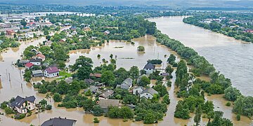 Ein Flu&szlig; ist &uuml;ber seine Ufer getreten und hat gro&szlig;e Teile der Landschaft und einer Ortschaft meterhoch unter Wasser gesetzt.