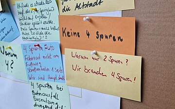 An einer Pinnwand sind Karten in verschiedenen Farben angepinnt. Auf ihnen haben B&uuml;rger ihre Meinung zur neuen Carolabr&uuml;cke in Dresden aufgeschrieben.