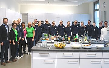 Ein gemeinsames Gruppenfoto von SUN und AOK in einer K&uuml;che.