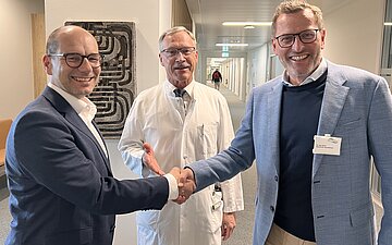Gruppenfoto mit Ronny Biehle, Stefan Riedl und Ingo H&uuml;ttner, die einander die H&auml;nde reichen.