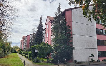 Foto: In einer begrünten Straße steht ein Gebäude.