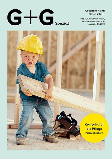 Foto: Ein kleiner Junge mit einem gelben Bauarbeiterhelm zieht eine Holzlatte.