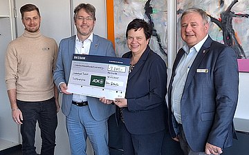 Übergabe Spendenscheck Übergabe eines großen Spendenschecks in Rastatt: Vier Personen schauen in die Kamera, in der Mitte halten zwei von ihnen einen großen Spendenscheck.