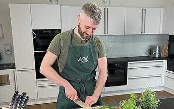 Mann beim Gem&uuml;se schneiden
