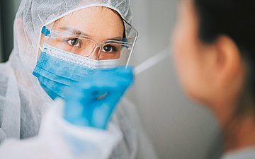 Foto einer Testerin in Schutzkleidung, die eine Frau testet