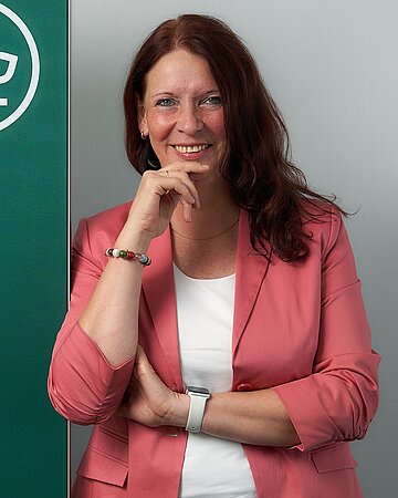 Portr&auml;tfoto: Martina Niemeyer lehnt an einem Roll-Up mit AOK-Logo