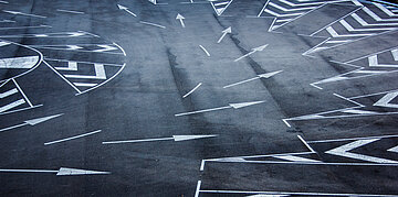 Foto: Pfeile auf einer Stra&szlig;e zeigen in unterschiedliche Richtungen.