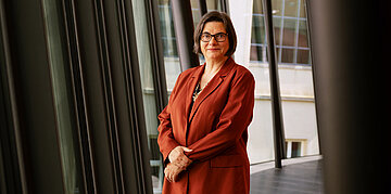Foto: Christine Fuchsloch, Pr&auml;sidentin des Bundessozialgerichtes (BSG), steht auf einem Gang vor einer Fensterfront.