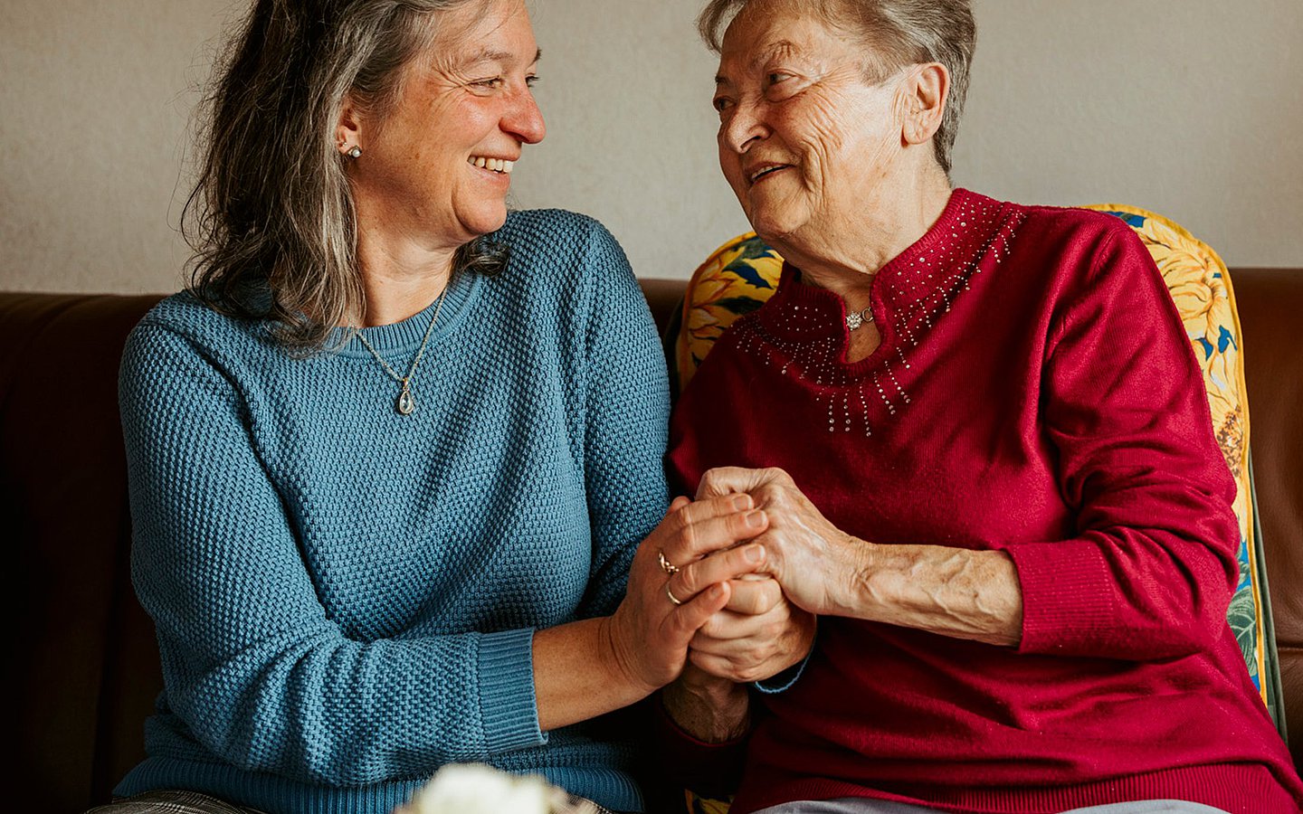 Foto von Patientenlotsin Veronika Hermle-Wehl (l.) und Patientin Josefine Greiner. Sie halten sich an den Händen.
