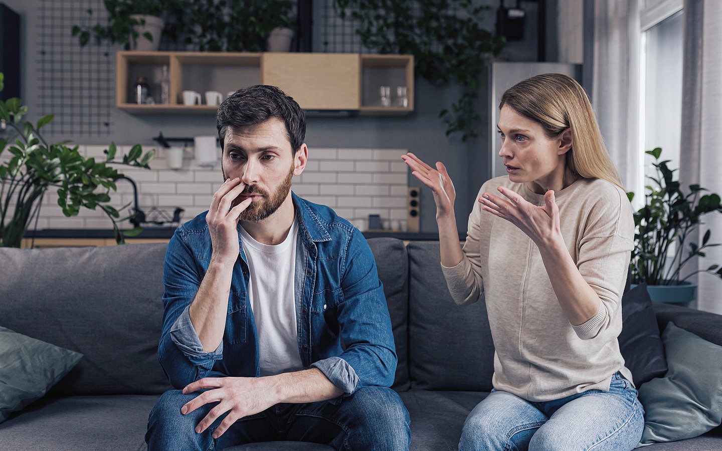 Midlifecrisis Foto: Frau redet auf Mann ein, beide sitzen auf dem Sofa.