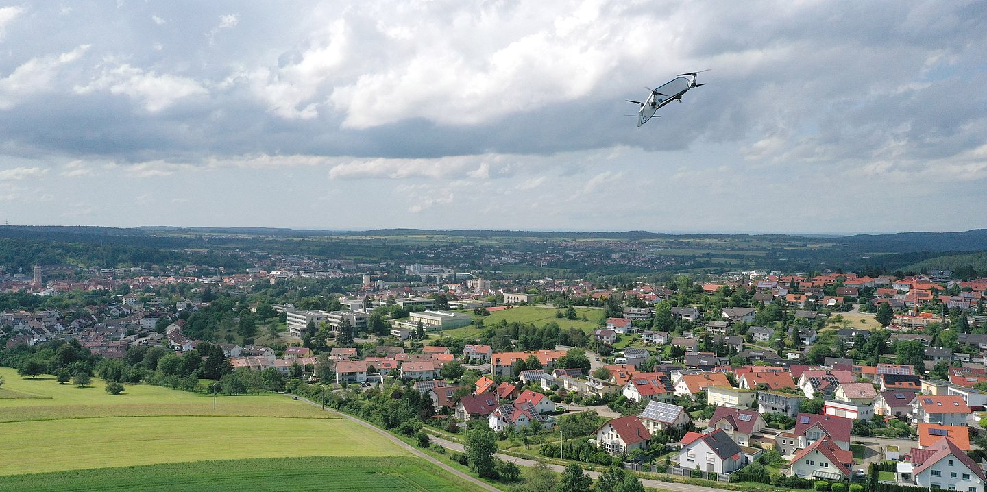 Bild einer Drohne, die über einer Ortschaft fliegt