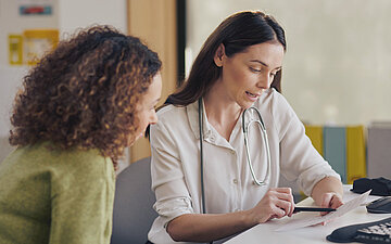 Eine &Auml;rztin bespricht die Behandlung mit ihrer Patientin.